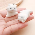 Detail of white flocked kitten pendants for DIY crafts shown on hand for size - 29x27x22mm / White Resin Flocked Split Puppy (24797)