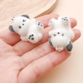 Close-up of white flocked puppy pendants with heart paw details and metal rings - 34x23x22mm / White Resin Flocked Sitting Puppy (24800)