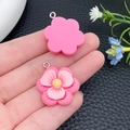 Detail van twee roze bloemhangers van hars met gele meeldraden en zilveren metalen ringen - Rozerode Hars Pruimenbloesem (24342)