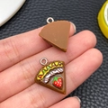 Macro-detail van hars chocoladetaart bedeltjes met aardbei en slagroom voor DIY sieraden - Driehoekige Aardbeientaart (24584)