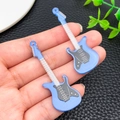 Detail shot of blue acrylic guitar charms showing printed strings and pickguard on hand - Blue (24055)