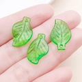 Vue macro de trois breloques feuilles en acrylique vert translucide pour bijoux DIY - Feuille Courte Irrégulière en Acrylique Vert (22145)