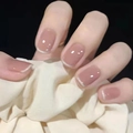 Unghie finte corte quadrate rosa nude con punte French bianche indossate sulla mano - S