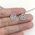 Detail of silver cat paw charms for DIY jewelry making showing texture and size - Antique Silver Double-Sided Paw (17371)