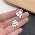 Macro detail of silver flame pendants for DIY jewelry held to show size and texture - Antique Silver Flame Style (21417)