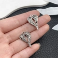 Close-up of vintage silver angel wing heart pendants held by hand for DIY jewelry - Antique Silver Heart Wing (21421)