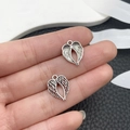 Detailed close-up of silver angel wing charms with intricate feather textures for DIY jewelry - Small Antique Silver Heart Wing (21422)