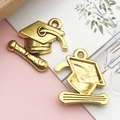 Macro detail of golden alloy graduation cap and scroll charms for DIY jewelry making - 1 Piece (17x17mm) / Antique Gold