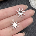Retro silver starburst pendant charms for DIY jewelry making shown in hand - Antique Silver Sun 16x19mm (7699)