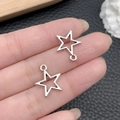 Silver hollow star charms with ring loops held by fingers for DIY jewelry making - Antique Silver Pentagram 14x17mm (18733)