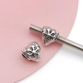 Detailed macro view of heart-shaped silver alloy beads with starburst relief patterns - Antique Silver Snowflake Heart Bead (15680)
