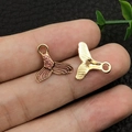 Macro detail of whale tail pendants showing scale texture and smooth gold back - Enamel Purple Mermaid Tail (10970)