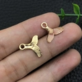 Detailed close-up of golden and pink enamel mermaid tail charms for DIY jewelry making - Enamel Pink Mermaid Tail (10968)