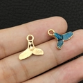 Macro view of gold whale tail pendants with blue enamel and textured metal finish - Enamel Blue Mermaid Tail (10967)