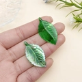 Detalle de colgantes de hojas en acrílico verde con vetas y acabado brillante - Hoja Marchita Verde AB (21965)