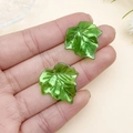 Primer plano de colgantes de hojas de acrílico verde translúcido para manualidades y bisutería - Hoja de Arce Verde Oscuro AB (21961)