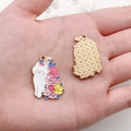Detailed macro view showing the enamel cat charm front and textured gold metal back - White Flower Cat