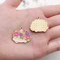 Macro view of colorful enamel hedgehog charms with floral details on palm for size reference - Pink Flower Hedgehog