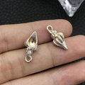 Silver conch shell pendant for DIY jewelry making shown on fingertip for scale - Enamel White Conch (8601)