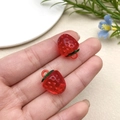 Detailed close-up of DIY acrylic strawberry charms with green leaves for jewelry making - Transparent Red Strawberry (22164)