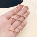 Primer plano de dos marcos huecos cuadrados chapados en oro para hacer joyas DIY - Marco Cuadrado Grande (13513)
