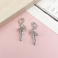Detalle macro de dos colgantes de bailarina en plata antigua sobre fondo decorativo - Bailarina Estilo D de Aleación de Zinc Plata Antigua