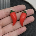Pendentifs piments rouges en résine avec anneaux métalliques tenus dans la main - Piment en Résine Rouge (19699)