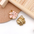 Close-up of pink flower pendants with rhinestones and gold-plated textured backs - Pink Enamel Gold Base Rhinestone Flower Style (16695)