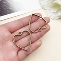 Dijes de corazón con bisel abierto en bronce antiguo para creación de joyas de resina - Bisel de Marco de Corazón (10491)