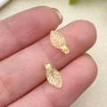 Macro shot of mini acrylic leaf pendants with detailed veins on a finger for DIY jewelry - Yellow Green Mini Leaf (22137)