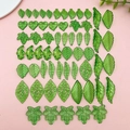 Flat lay of green acrylic leaf pendants in various shapes for DIY jewelry making - Acrylic Small Leaf Assorted Styles (SN1124)