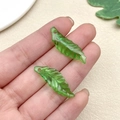 Detail of green acrylic leaf charms showing realistic vein texture and pre-drilled holes - Small Irregular Long Leaf (22156)
