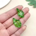 Detailed shot of two transparent green acrylic leaf pendants with intricate vein textures - Wavy Leaf (22154)