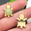 Detailed close-up of a pair of turtle charms with green stones and engraved golden shells - Light Green Glace Zinc Alloy Turtle (22203)