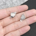 Detail of silver heart-shaped magnetic jewelry clasps with rhinestones held in hand - Silver