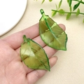 Translucent green acrylic ginkgo leaf pendants shown in hand for size visualization - Light Green Large Leaf (54x29mm)