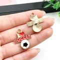 Hand holding DIY soccer pendant and gold textured charm set for jewelry making - I Love Soccer Mix (16737)