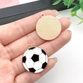 Enamel football charm with gold backing for DIY jewelry, shown in a hand-held close-up - White Soccer Ball (21718) / 28x25mm