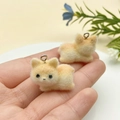 Close-up of mini flocked puppy charms with metal rings held in hand for DIY jewelry making - Light Brown Lying Puppy (23137)