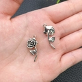 Detalle de dos colgantes de rosa plateados vintage para proyectos de joyería DIY - Flor de Rosa de Plata Antigua 11x26mm (Ref. 16925)