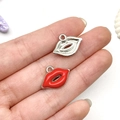 Detailed view of red and silver lip-shaped enamel charms held in hand for DIY jewelry - Red Lips Style (21939)