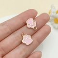 Gros plan de petits pendentifs pattes de chat rose et or pour bijoux DIY sur le bout des doigts - Double Face Or KC Rose (23315)