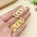 Primer plano de dijes de metal dorado 2026 con acabado de esmalte amarillo para joyas - Grande 2026 Amarillo (23352)