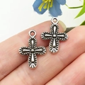 Pendentifs croix argentés vintage avec texture perlée présentés sur le bout du doigt - Croix en Alliage de Zinc Argent Antique 19x14mm (22332)