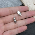 Silver oval magnetic jewelry clasps for DIY bracelet making held in hand for scale - Silver Ingot Shape (19857)