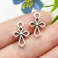 Lot de deux pendentifs croix évidés argentés présentés sur le bout du doigt pour taille - Croix Creuse en Alliage de Zinc Argent Antique 11x16mm (18724)