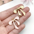 Detail of pink oil drip and gold alloy bow pendants for DIY jewelry and accessories - Alloy Bow knot