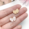 Close-up of pink enamel and golden metal bow pendants for DIY jewelry making - Pink Bowknot
