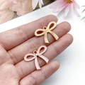 Macro shot of sweet pink enamel bow charm and gold alloy pendant for DIY jewelry - Large Hollow Bowknot