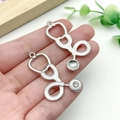 Dettaglio di ciondoli a forma di stetoscopio in argento e smalto bianco per gioielli fai da te - Stetoscopio in Cristallo Grande Argento Bianco (23221)